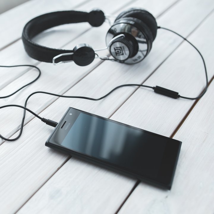 Smartphone mit Kopfhörern auf Tisch